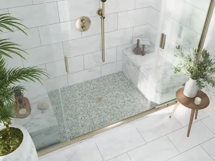 Modern shower with Waterford mint green marble mosaic tile floor and white marble wall tiles with gold fixtures.